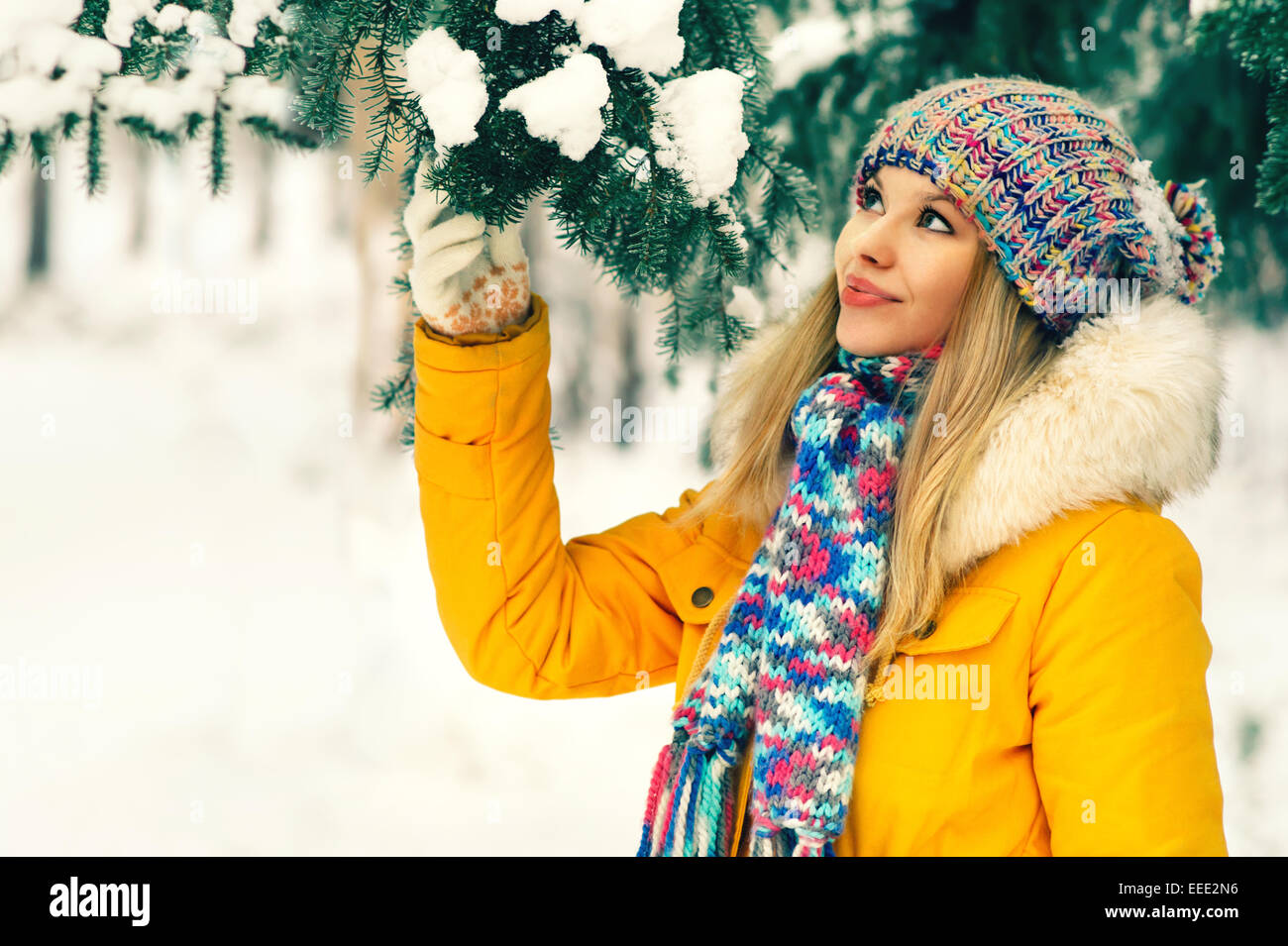 Giovane donna Outdoor Lifestyle invernale nel cappello e muffole di moda abbigliamento azienda abete del ramo La neve natura sullo sfondo Foto Stock