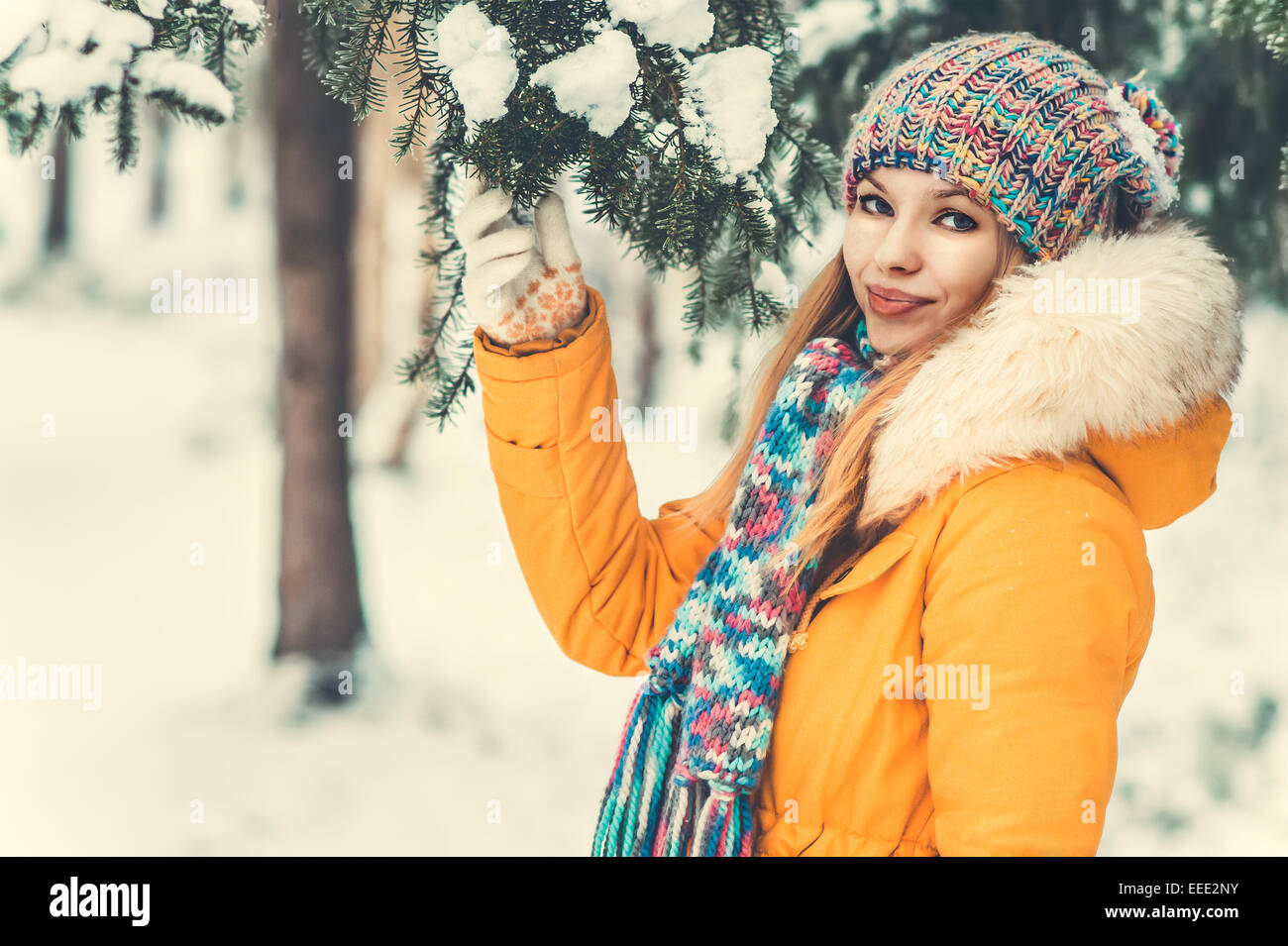 Giovane donna Outdoor Lifestyle invernale nel cappello e muffole di moda abbigliamento azienda abete del ramo La neve natura sullo sfondo Foto Stock