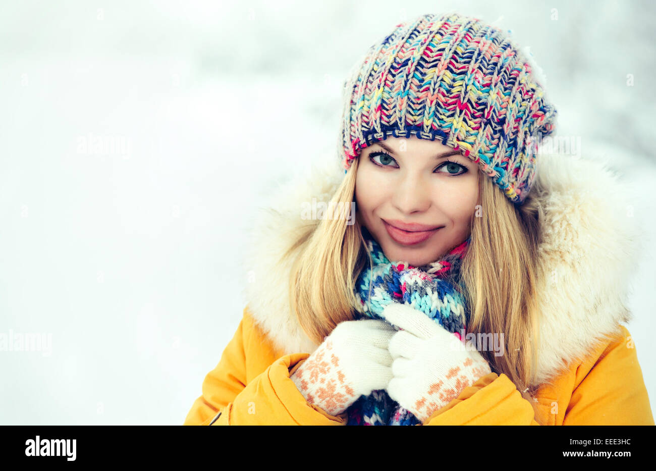 Inverno donna faccia sorridenti nella maglieria hat moda abbigliamento outdoor Lifestyle Viaggi natura neve sullo sfondo Foto Stock