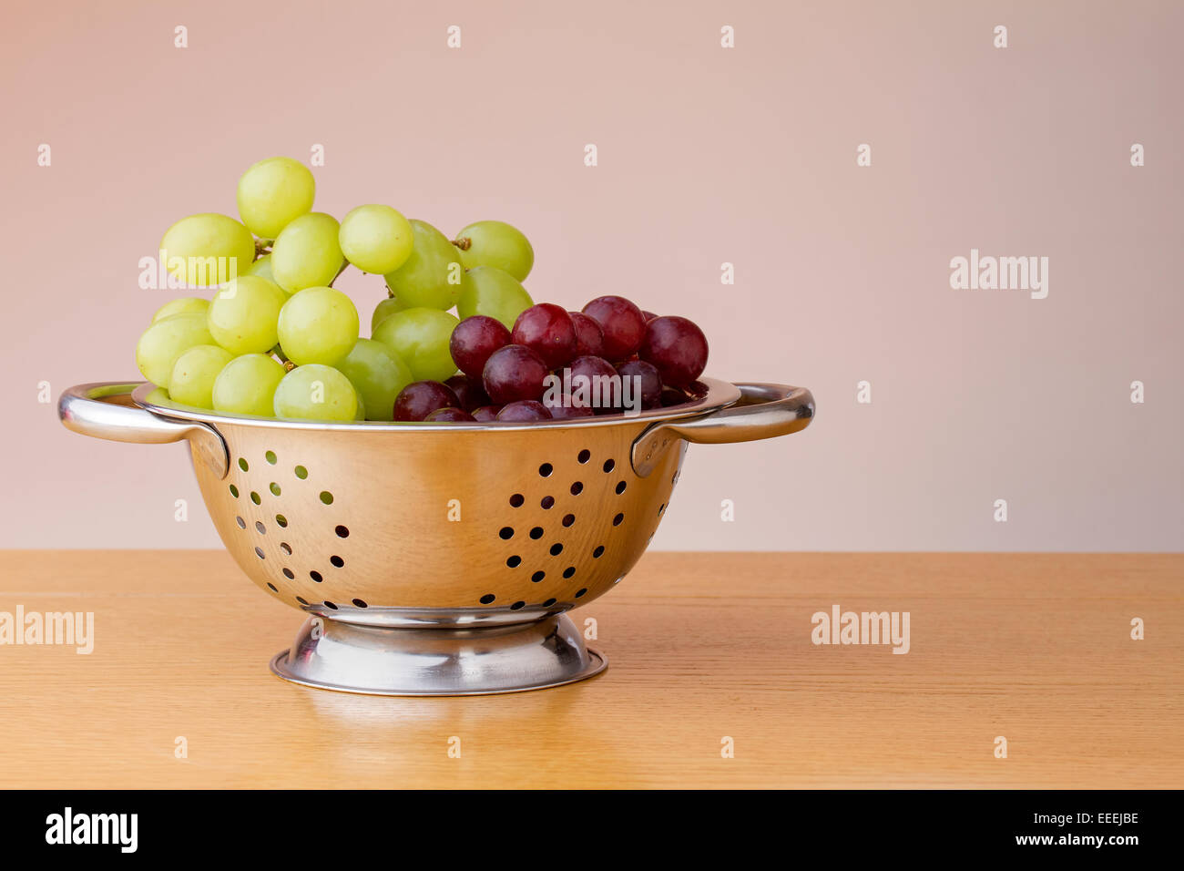 Il rosso e il verde uva in uno scolapasta Foto Stock