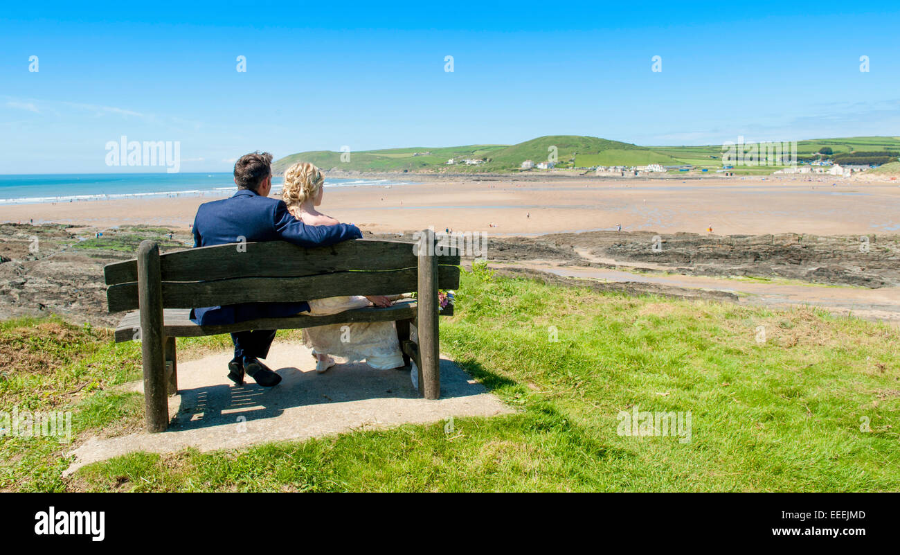 Appena una coppia sposata su una spiaggia affacciata sul mare Foto Stock