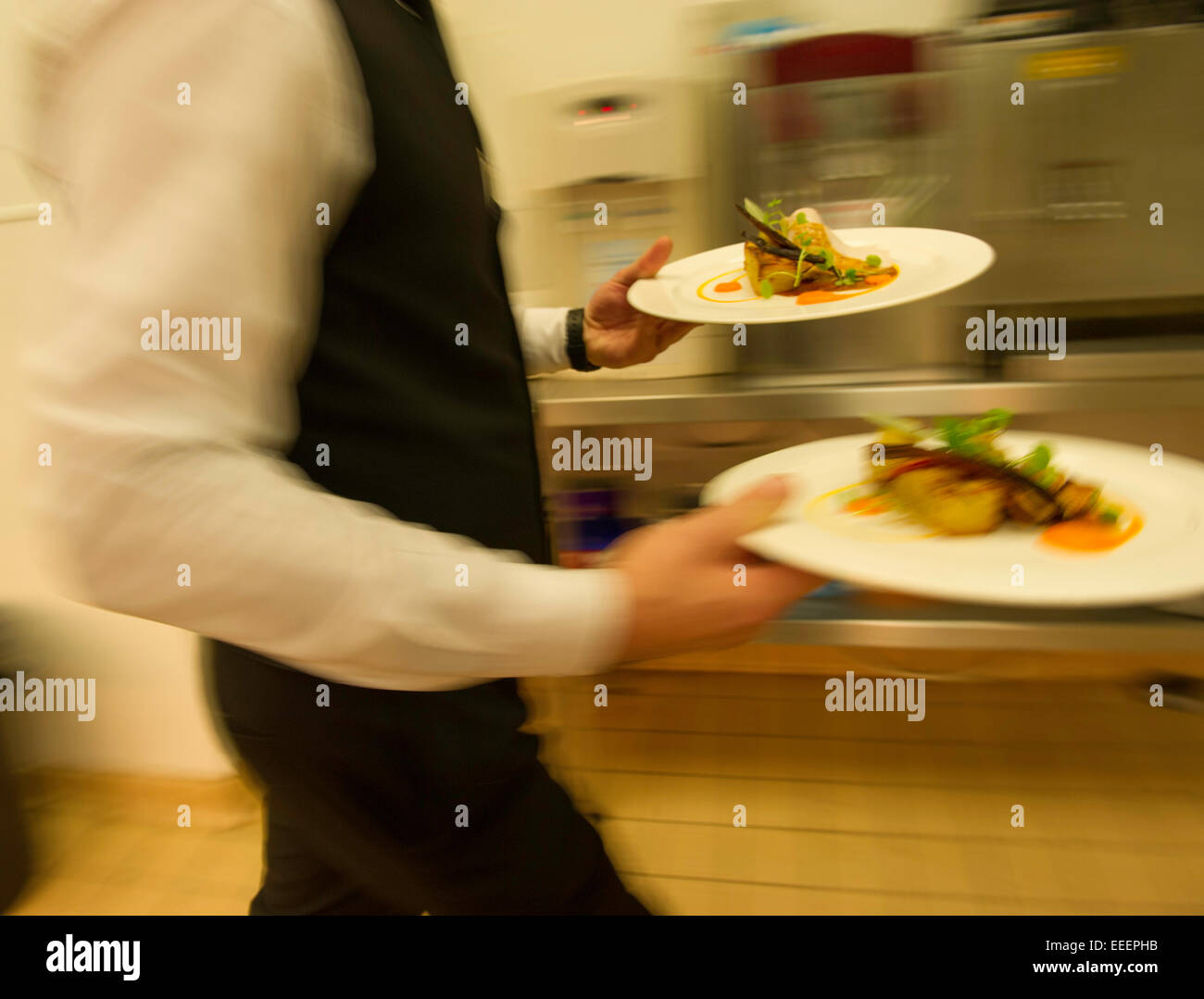 Una cameriera per portare cibo dalla cucina Foto Stock