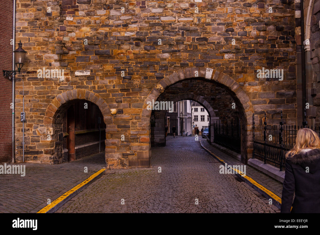 Donna cammina verso la Servaasbasiliek st. Archi presso il west end di San Servazio Basilica a Maastricht nel Limburgo, Paesi Bassi Foto Stock