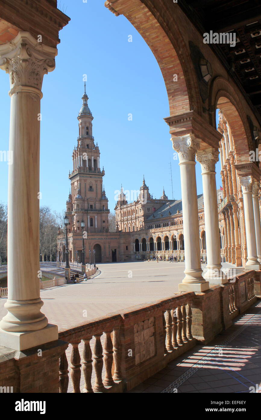 Colonnato con archi che incorniciano la alta torre sud a Siviglia di Plaza de España (Piazza di Spagna) Foto Stock