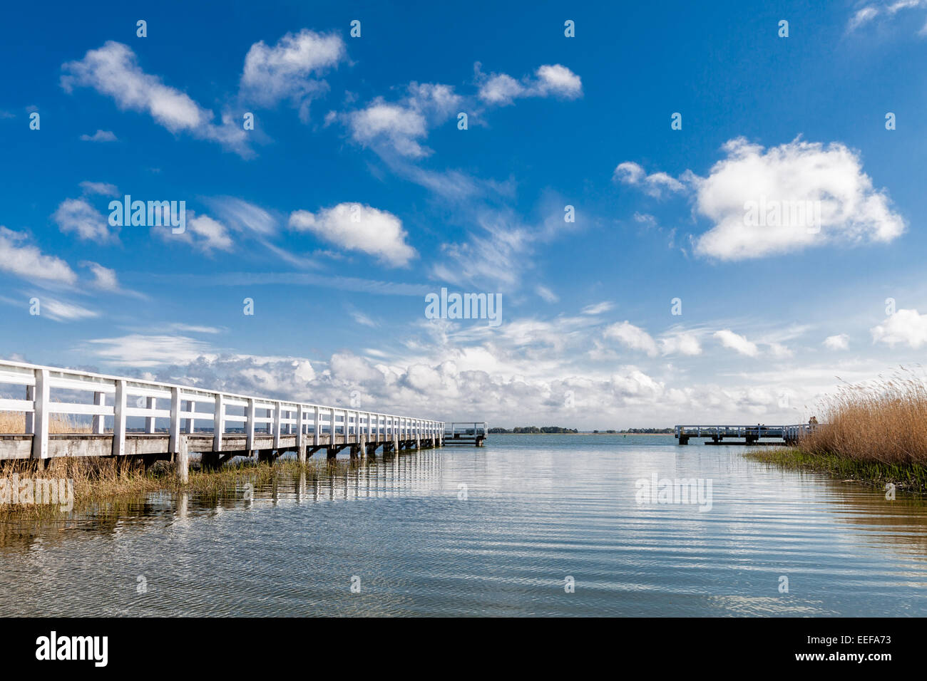 Lago con Pier e le nuvole nel cielo blu Foto Stock