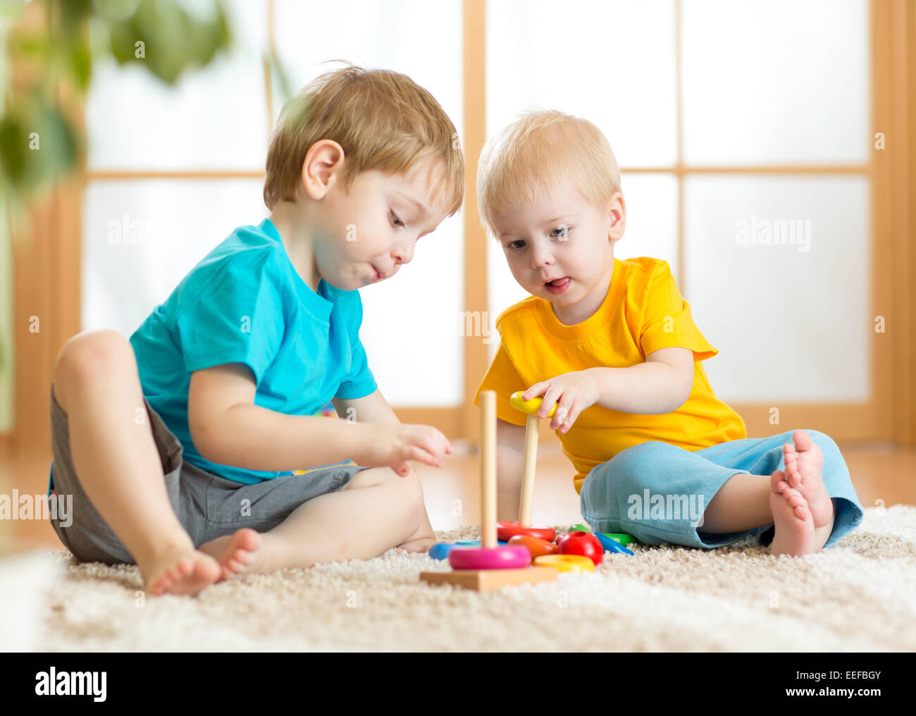 Bambini I ragazzi con i giocattoli in sala giochi Foto Stock