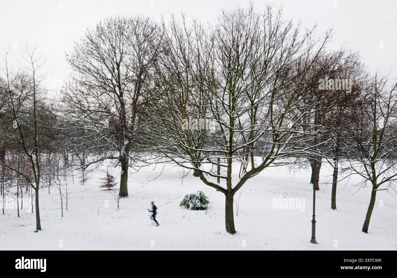 Figure sfocate correre e camminare nella neve su un parco a Londra in Inghilterra Foto Stock