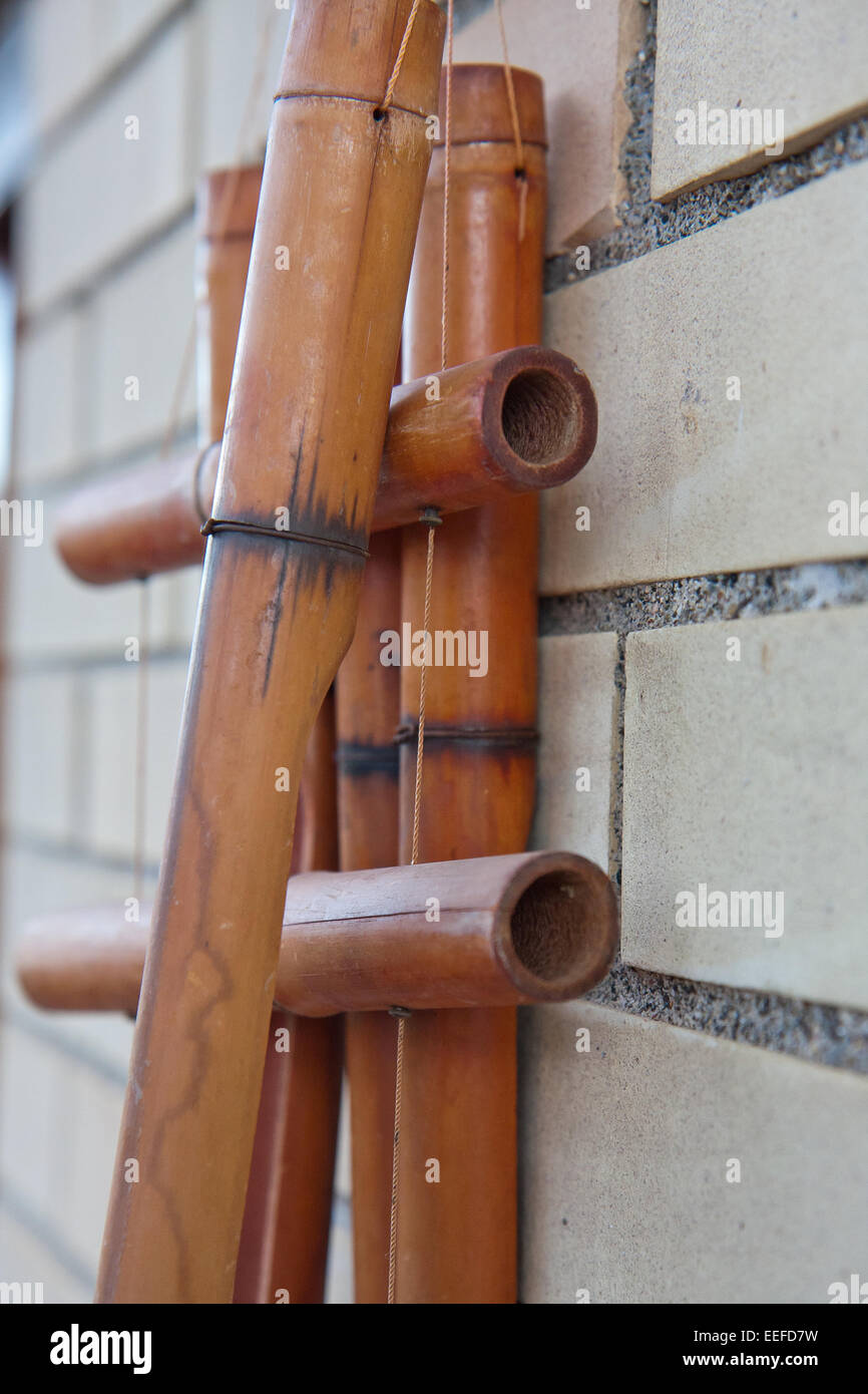 Ornamento di bambù appeso su ON mentre il muro in mattoni Foto Stock