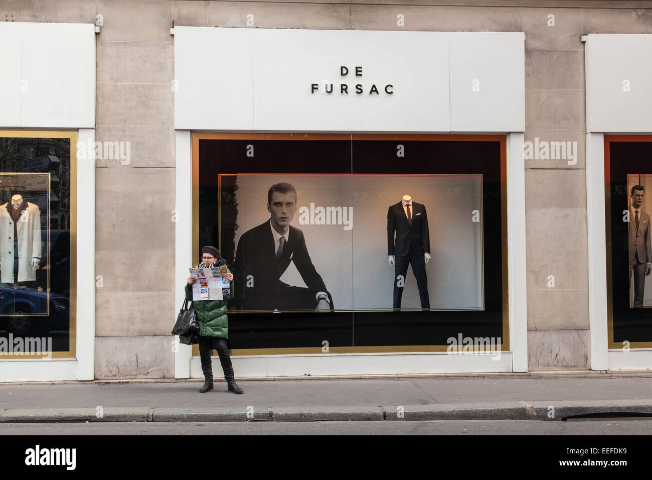 Un turista guardando una mappa al di fuori di un De Fursac uomini suit store, Pars, Francia Foto Stock