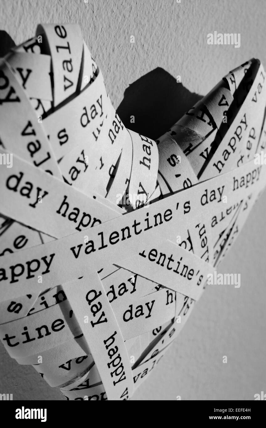 Primo piano di un cuore fatto con le strisce di carta con il testo happy valentines scritto in in bianco e nero Foto Stock