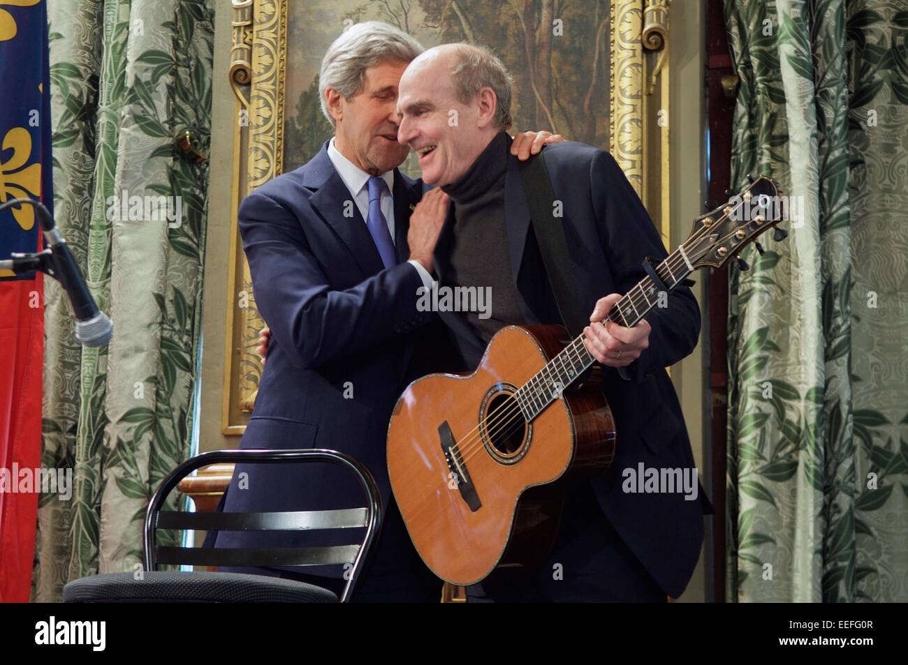 Il Segretario di Stato americano John Kerry abbraccia il cantante James Taylor dopo aver finito di cantare "Hai un amico' in corrispondenza di un evento a Parigi City Hall di onorare le vittime degli attacchi terroristici nella capitale francese 16 gennaio 2015 a Parigi, Francia. Foto Stock