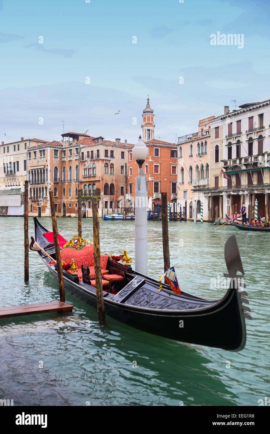 Gondola vuota parcheggiata in un campo Erberia quadrato sul canal grande con la gondola con turisti di passaggio dietro di esso a Venezia, Italia. Foto Stock