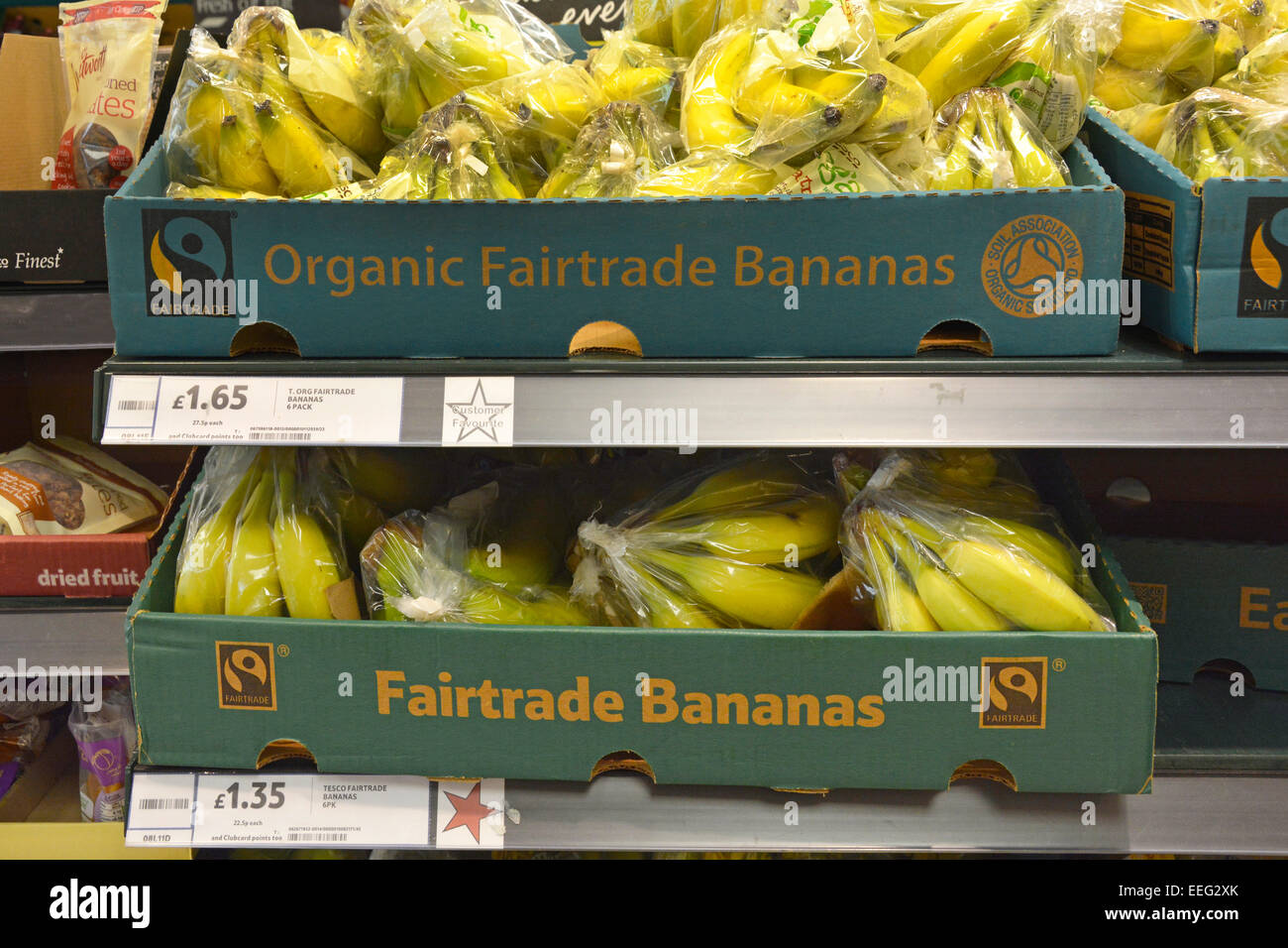 Biogico cibo Fairtrade matura banane fresche in scatole esposte sugli scaffali frutta in vendita interno grande Tesco alimentari supermercato negozio Londra Inghilterra UK Foto Stock