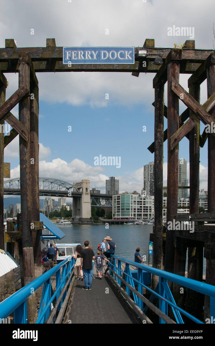 Dock di traghetti e di passeggeri, Granville Island, Vancouver, British Columbia. In lontananza si vede il ponte Burrard Foto Stock