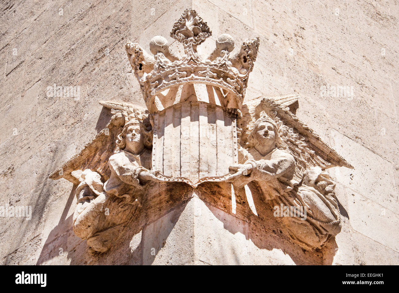 Dettagli architettonici di una facciata ornata da due angeli recanti una corona a Valencia, Spagna Foto Stock
