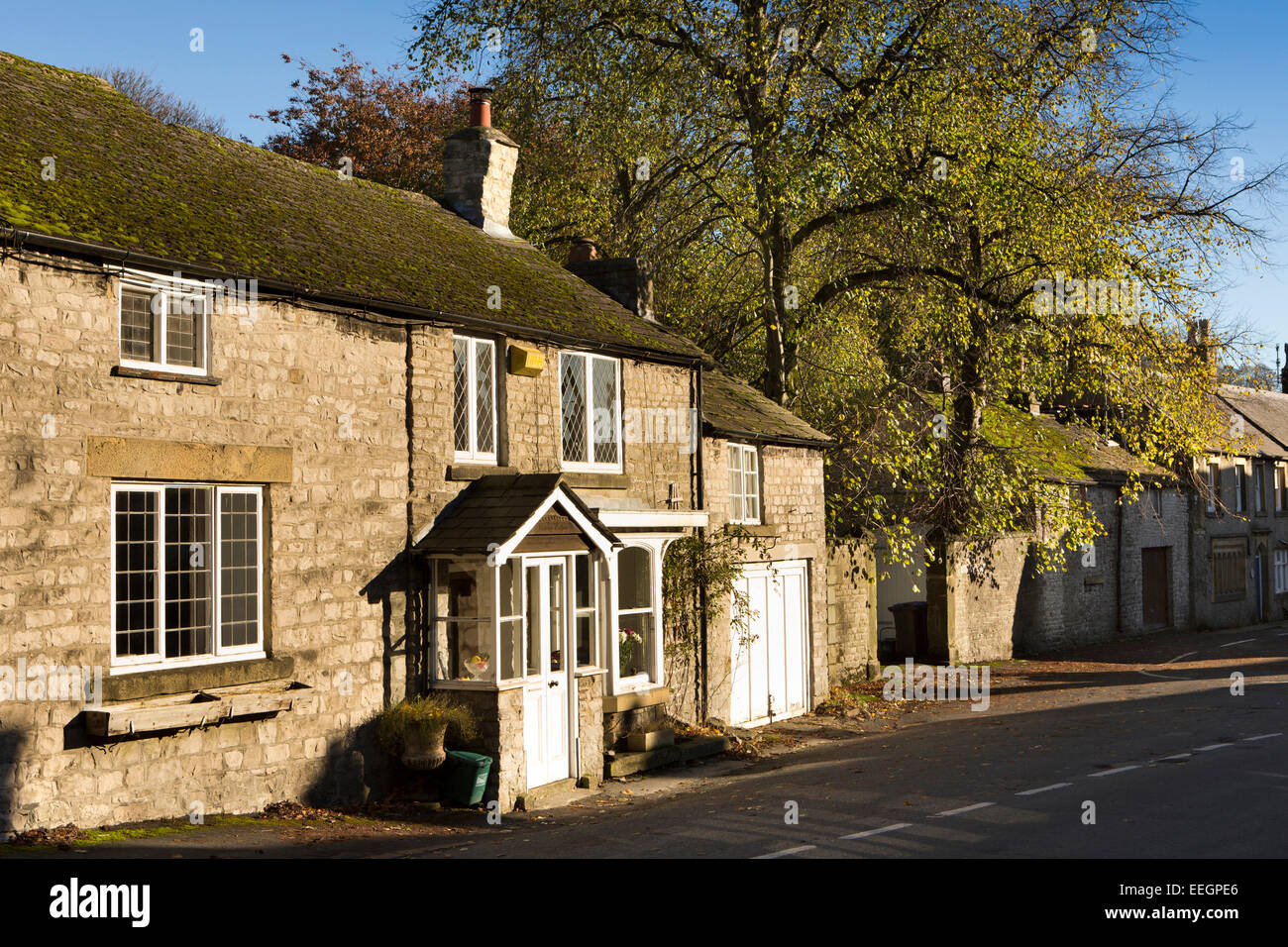 Regno Unito, Derbyshire, Tideswell, High Street, luce autunnale su Vicarage Cottage Foto Stock