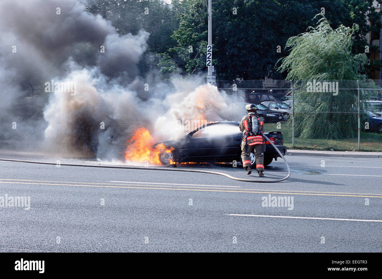 Fireman mettendo fuori fuoco auto in Toronto Ontario Foto Stock