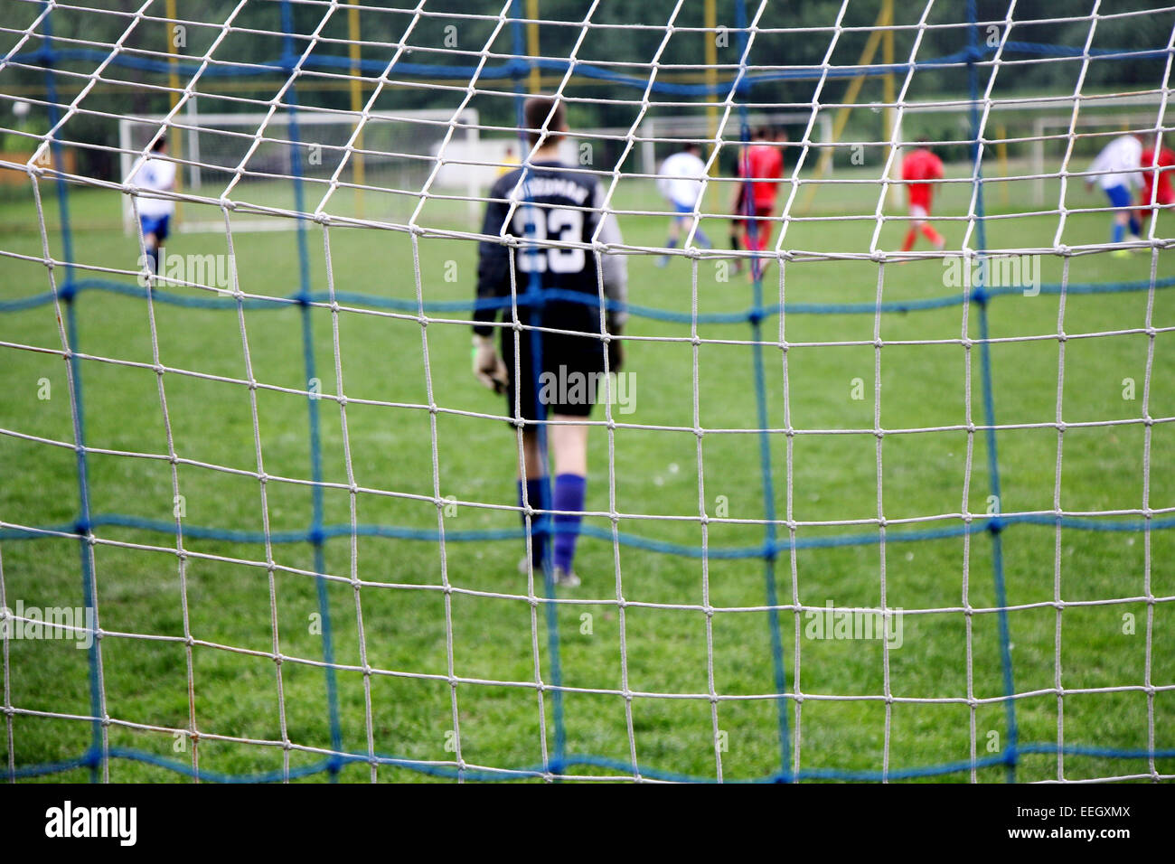 Obiettivo di calcio si ingranano con i giocatori di calcio in azione sullo sfondo soft focus Foto Stock