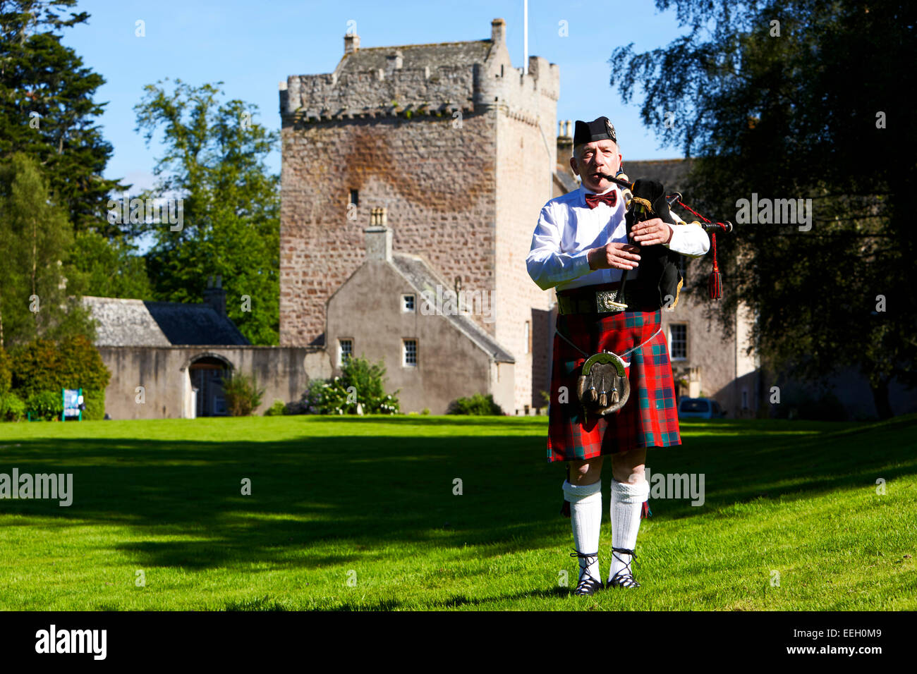 Cornamuse scozzesi giocatore giocare tubi nella parte anteriore del castello di Scozia Foto Stock