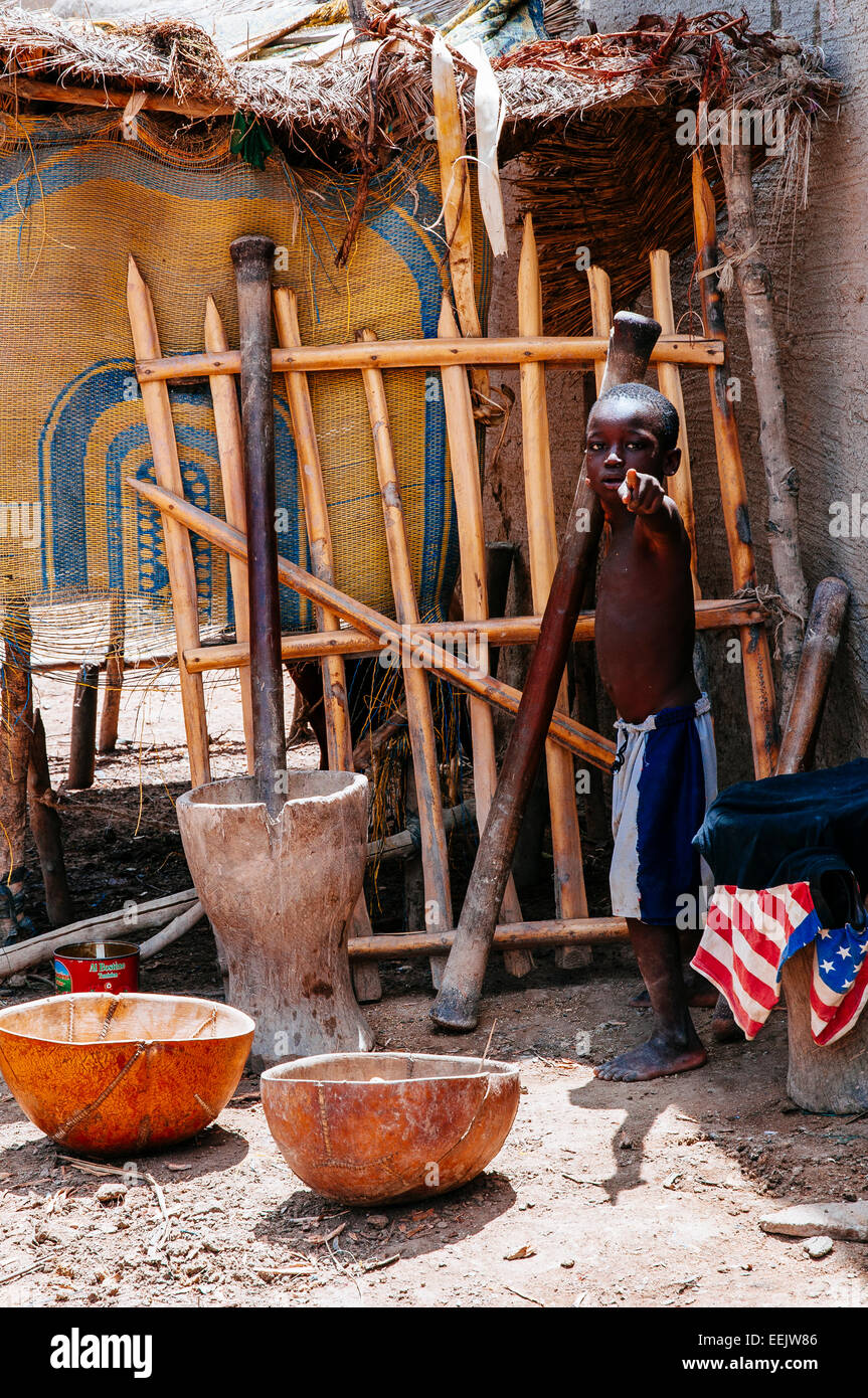 Ragazzo di miglio di macinazione in modo tradizionale, Djenne, Mali. Foto Stock