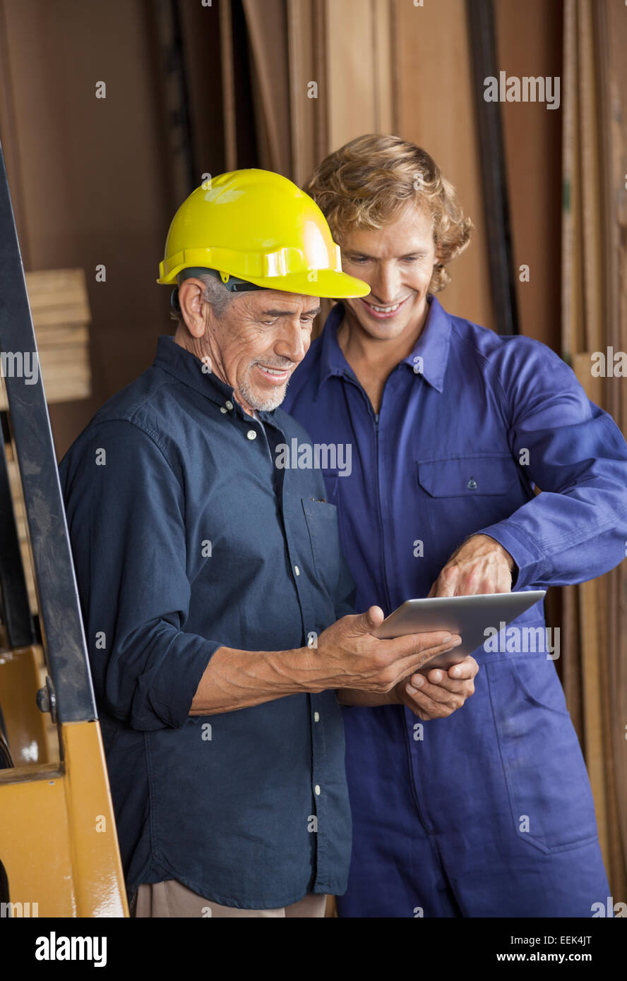 Falegnami utilizzando computer tablet in officina Foto Stock