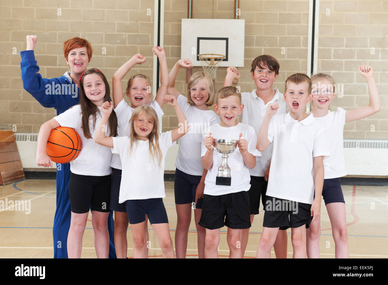 Scuola Basket Tean e Coach celebrando la vittoria con il trofeo Foto Stock