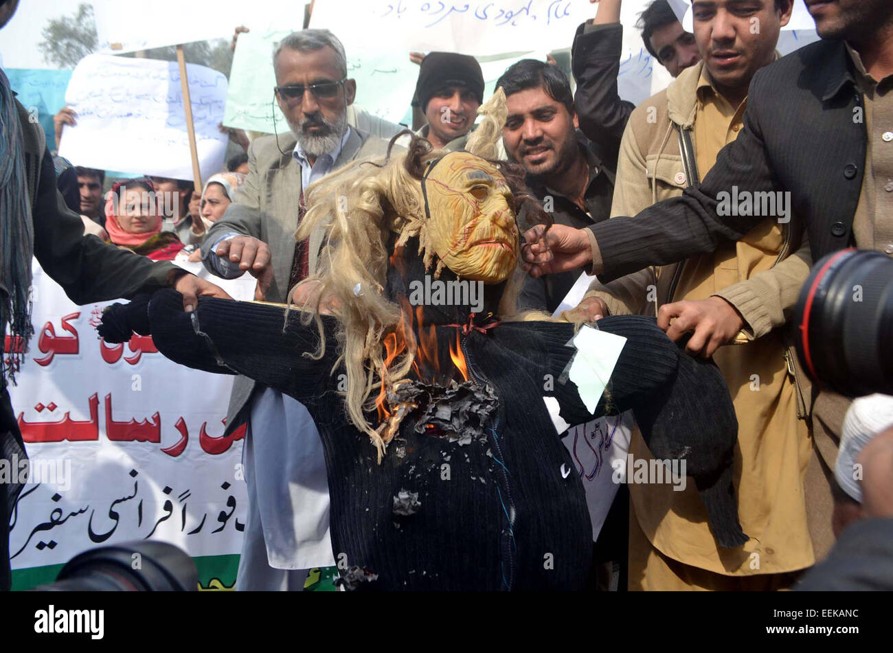 I membri nazionali del Comitato per la pace armonia interconfessionale masterizzare effige come stanno protestando contro la pubblicazione delle caricature blasfemo nella rivista francese Charlie Hebdo durante la dimostrazione a Peshawar press club il lunedì, 19 gennaio 2015. Foto Stock