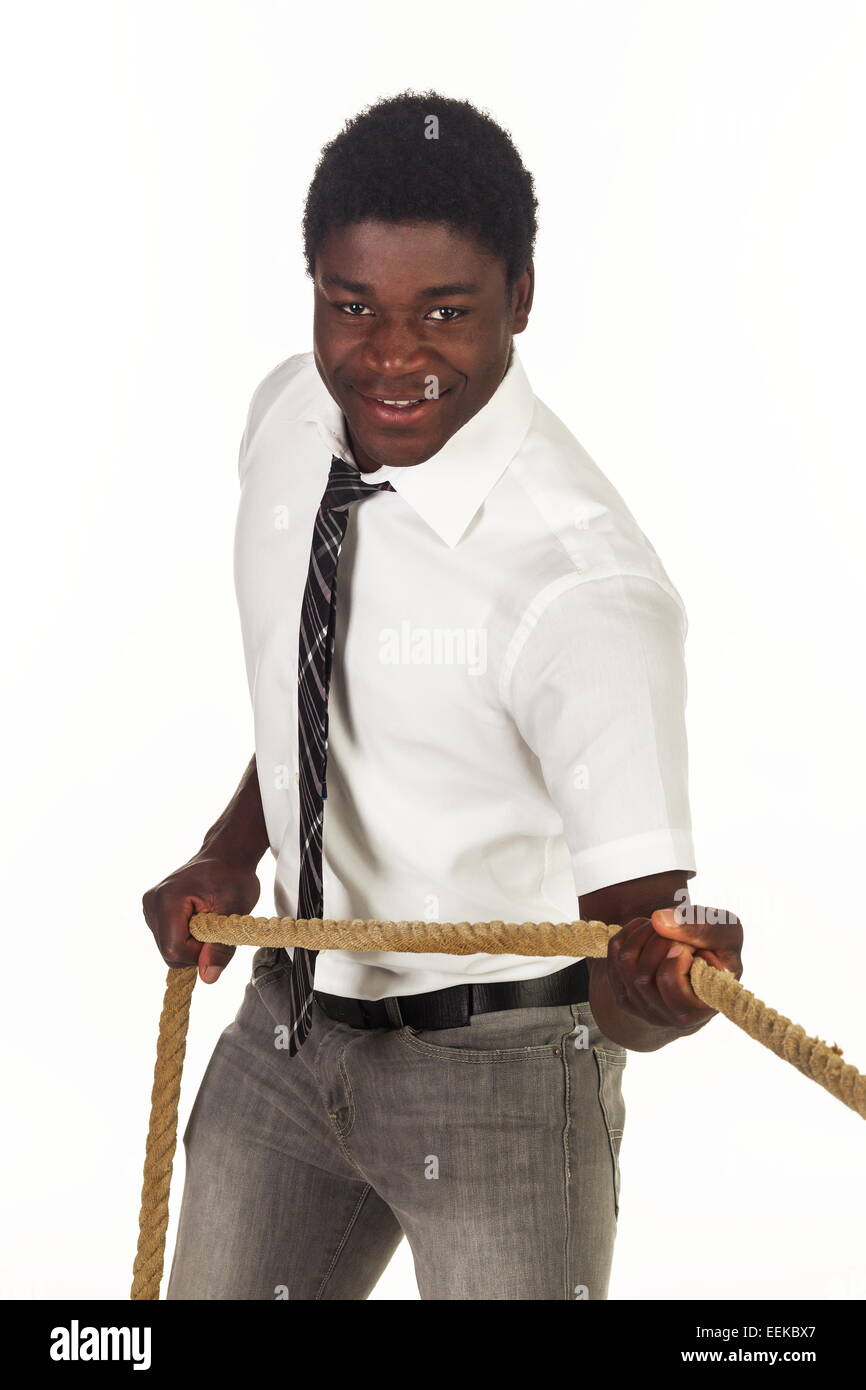 Junger dunkelhäutiger Mann mit Hemd und Krawatte zieht un einem Tau Foto Stock