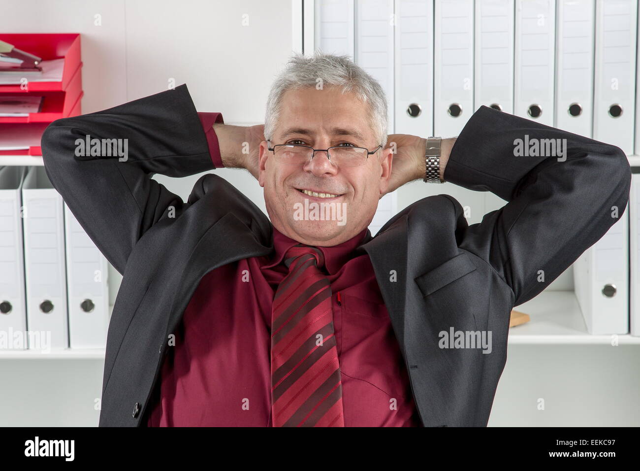 Mann mittleren altera sitzt im Büro und relext, uomo di mezza età seduto in un ufficio, rilassante Foto Stock