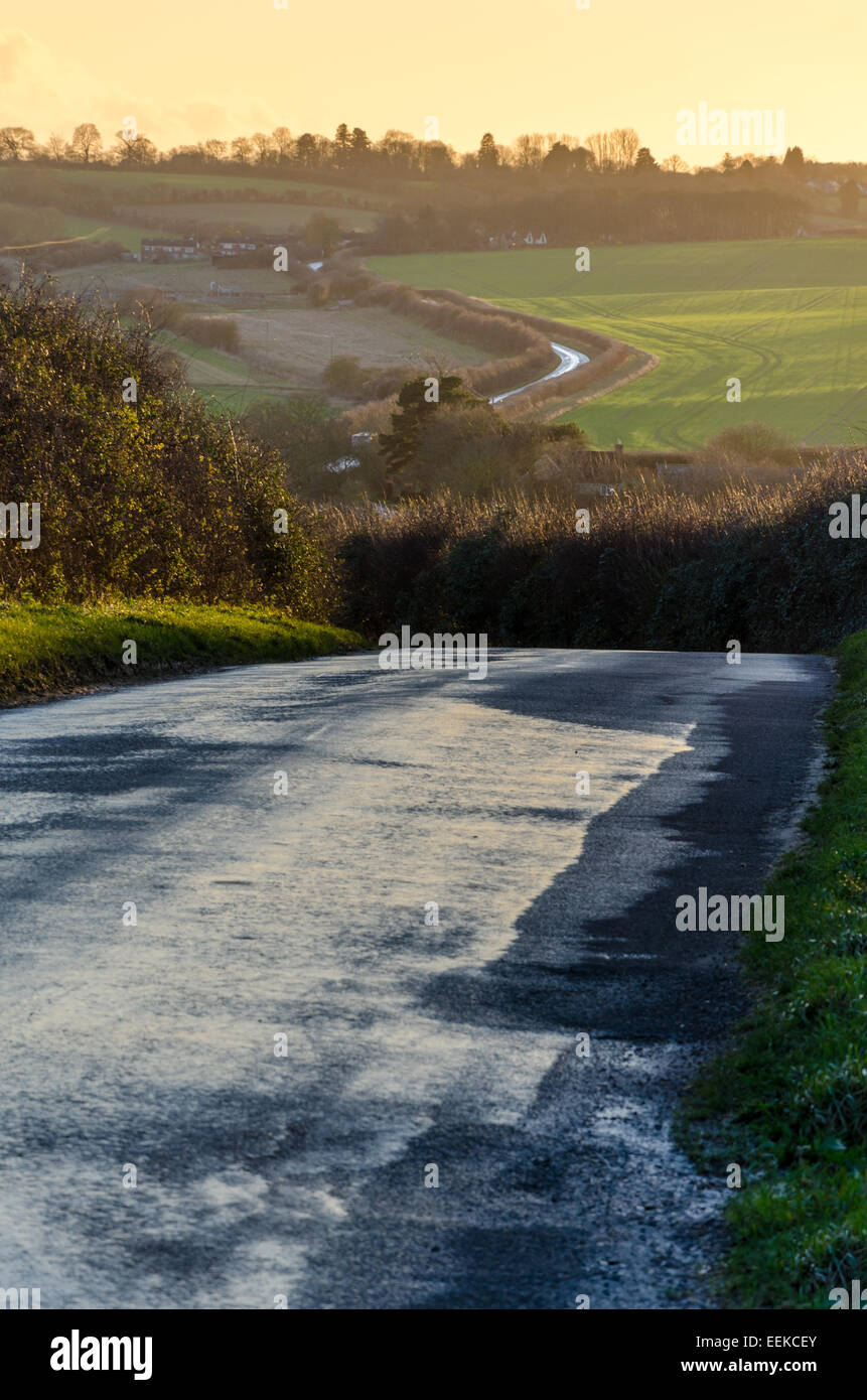 Impostazione di Sun in un paese bagnato road NEL REGNO UNITO Foto Stock