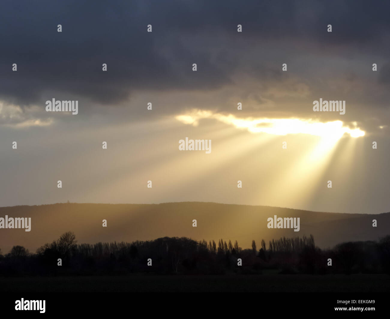 Un raggio di sole fa capolino tra le nuvole scure Foto Stock