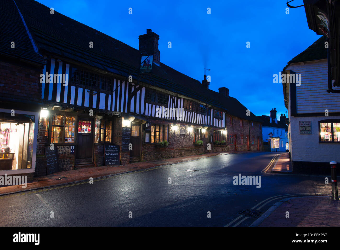 Il mezzo in legno George Inn illuminata su una sera d'inverno, Alfriston, East Sussex, Regno Unito Foto Stock
