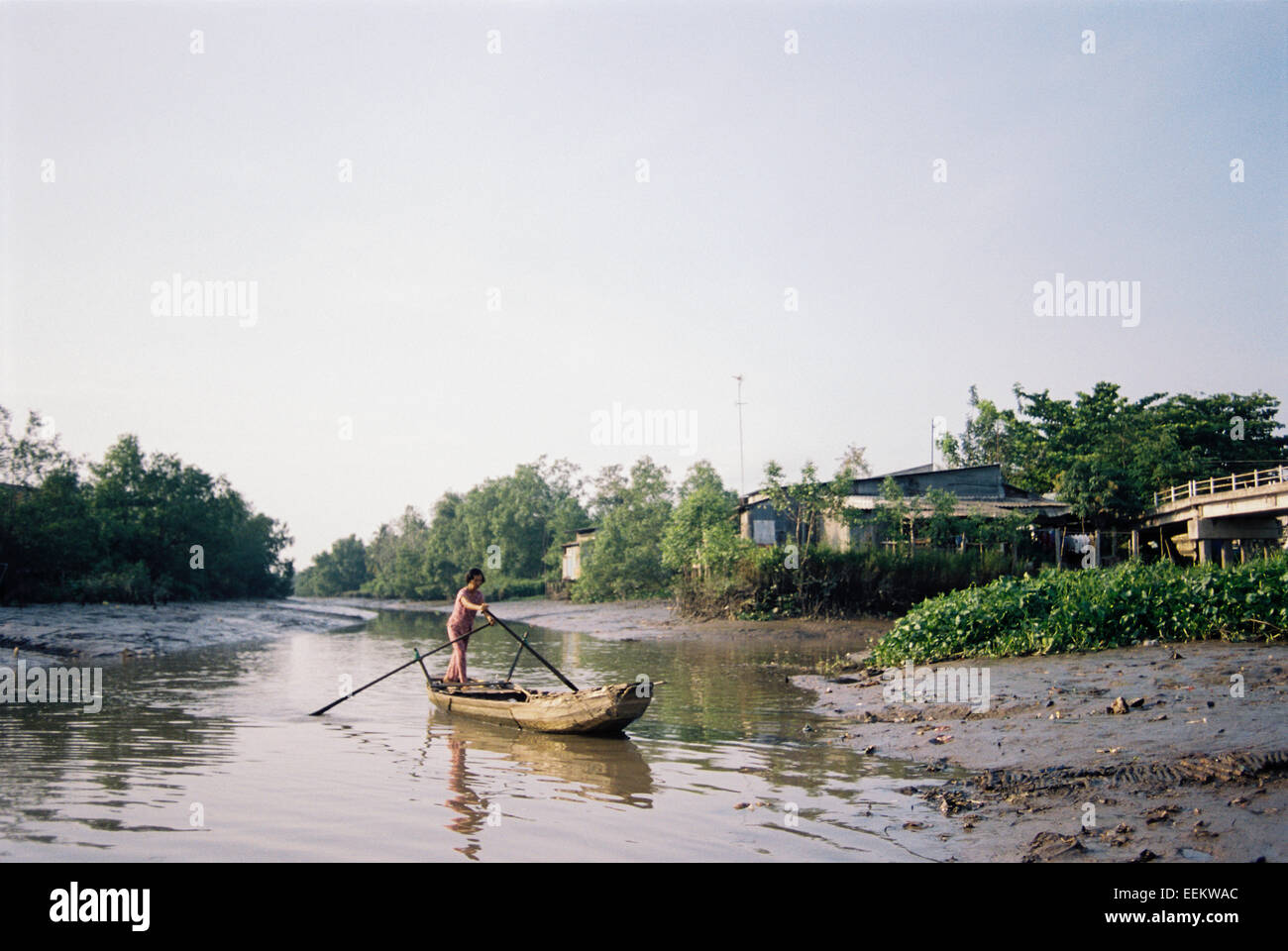 Femmina lavoratore in traghetto sul fiume Mekong tributario, Delta del Mekong Foto Stock