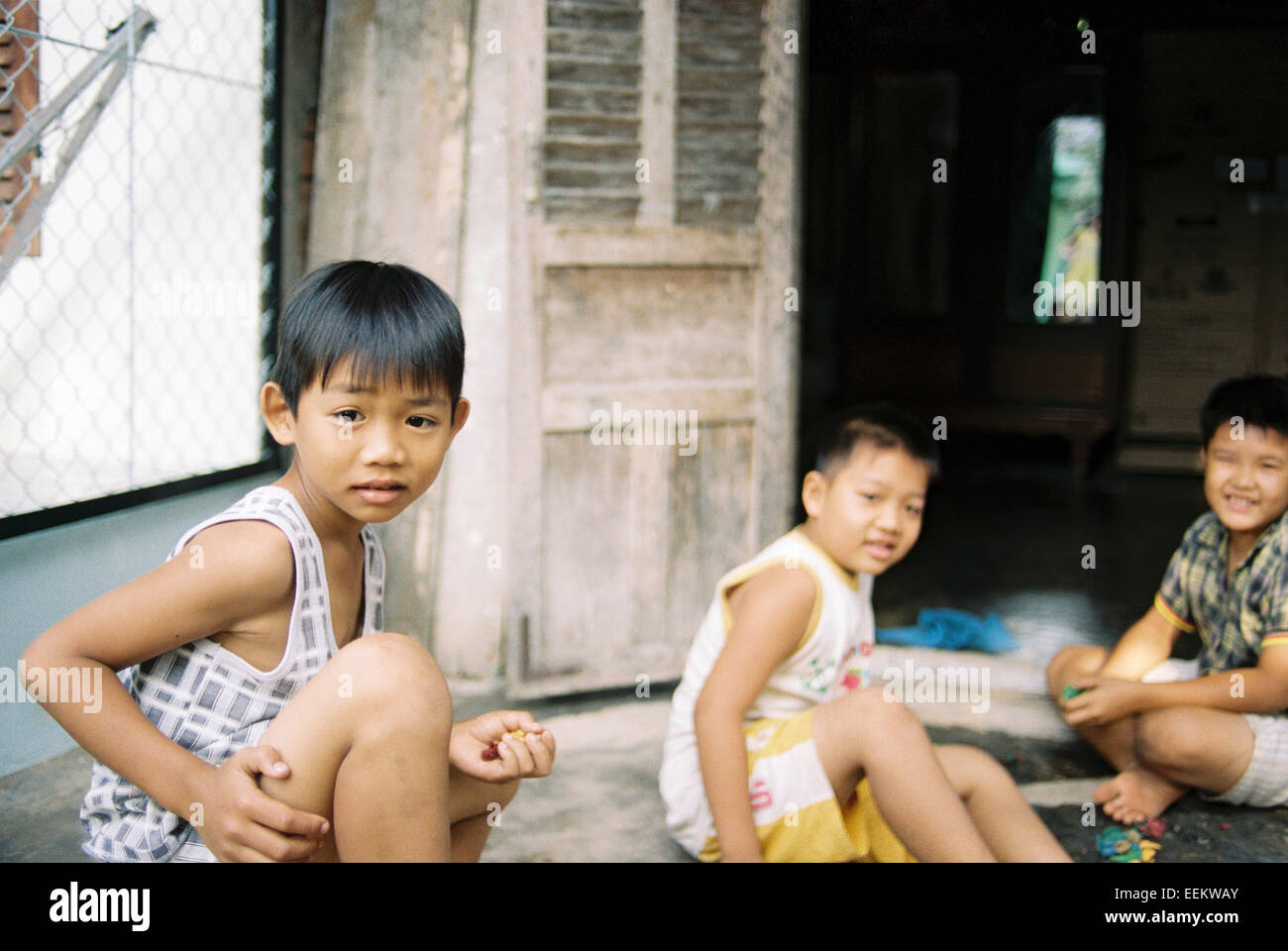 3 giovani ragazzi giocare vicino al mercato, il Delta del Mekong Foto Stock