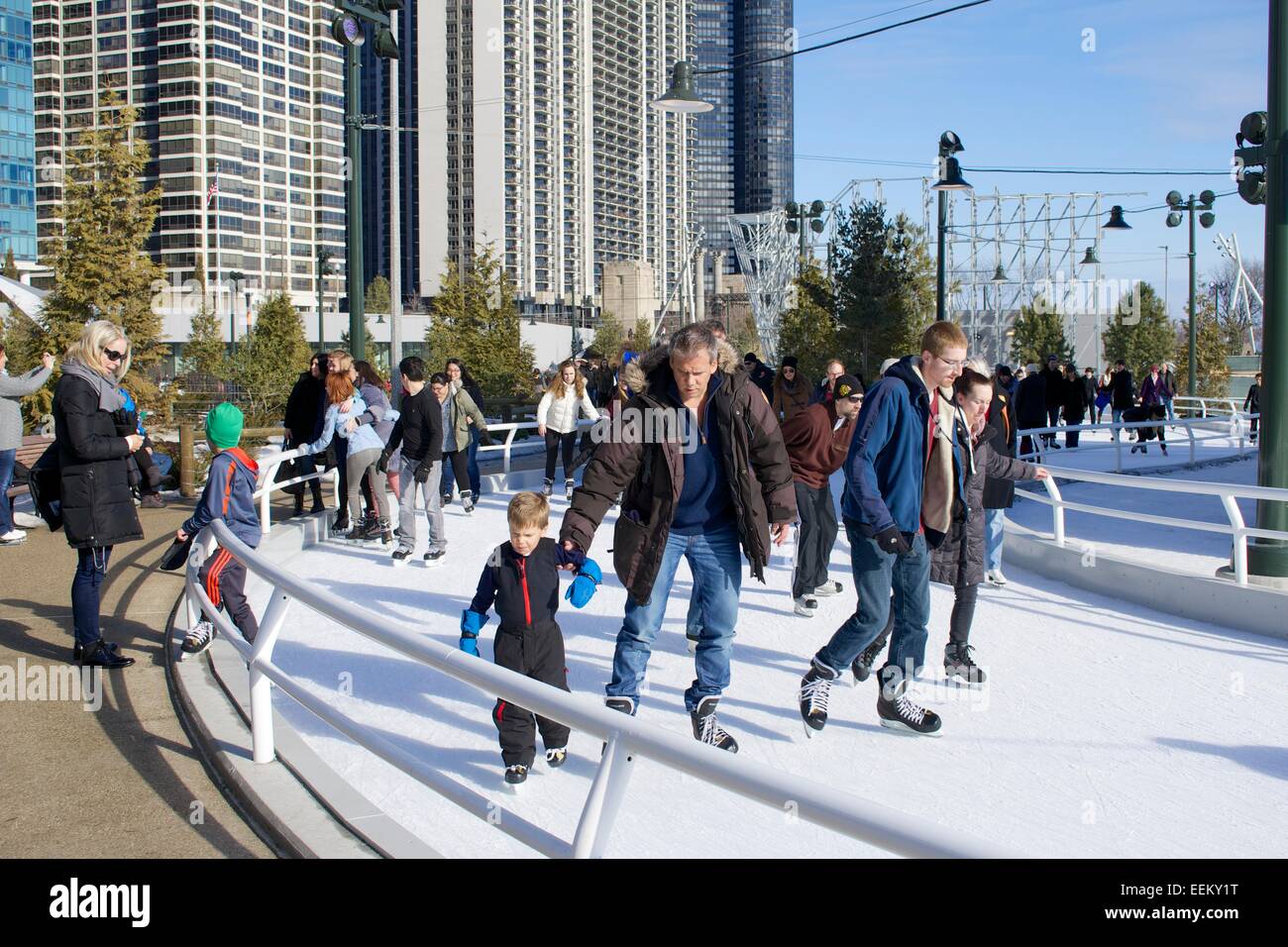 L'uomo antiribaltamento il suo figlio, il pattinaggio su ghiaccio a nastro. Maggie Daley Park, Chicago, Illinois. Foto Stock