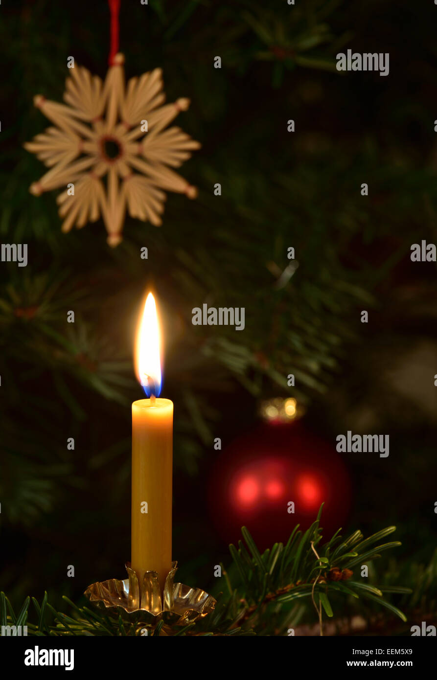 Brennende Kerze un Weihnachtsbaum, Weihnachtsschmuck, Strohstern, Weihnachtsbaumkugel Foto Stock