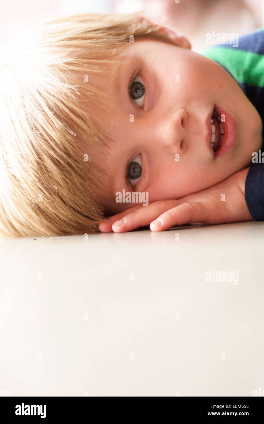 Ritratto di ragazzo sdraiato sul pavimento Foto Stock