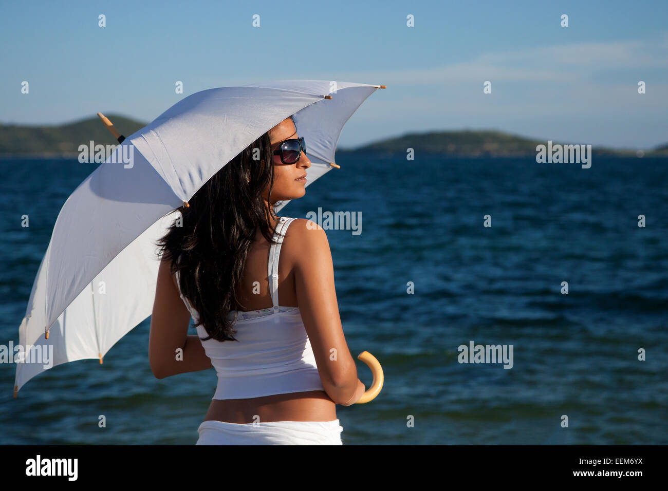 Giovane donna con ombrello bianco Foto Stock