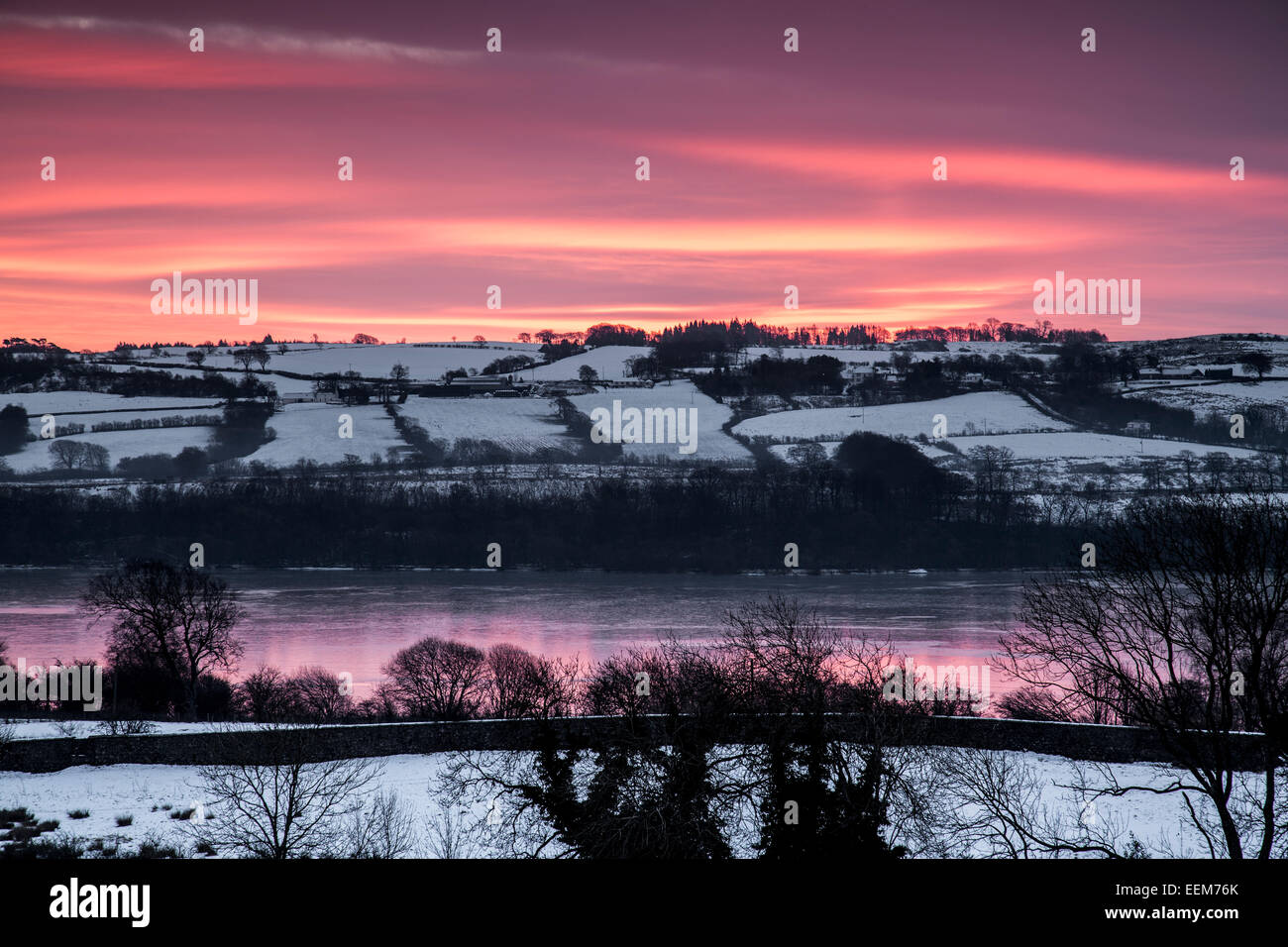 Lochwinnoch, Renfrewshire, Scozia, Regno Unito, martedì 20 gennaio 2015. Il sole sorge sopra il Castello di Semple Loch e la campagna circostante a seguito delle gelide temperature notturne Foto Stock