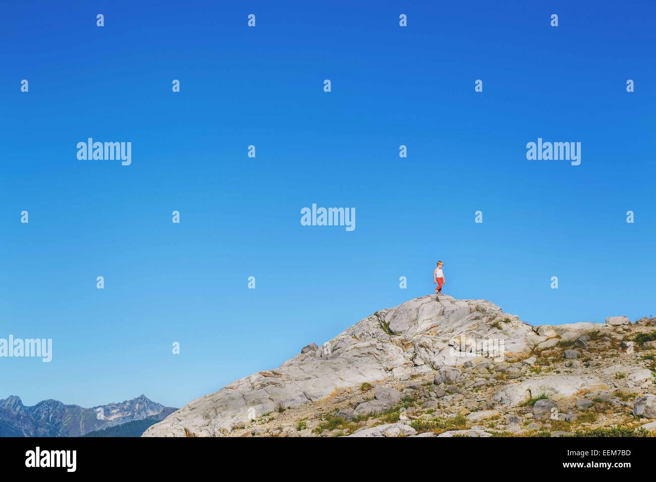 Ragazzo in piedi su una collina rocciosa, Stati Uniti Foto Stock