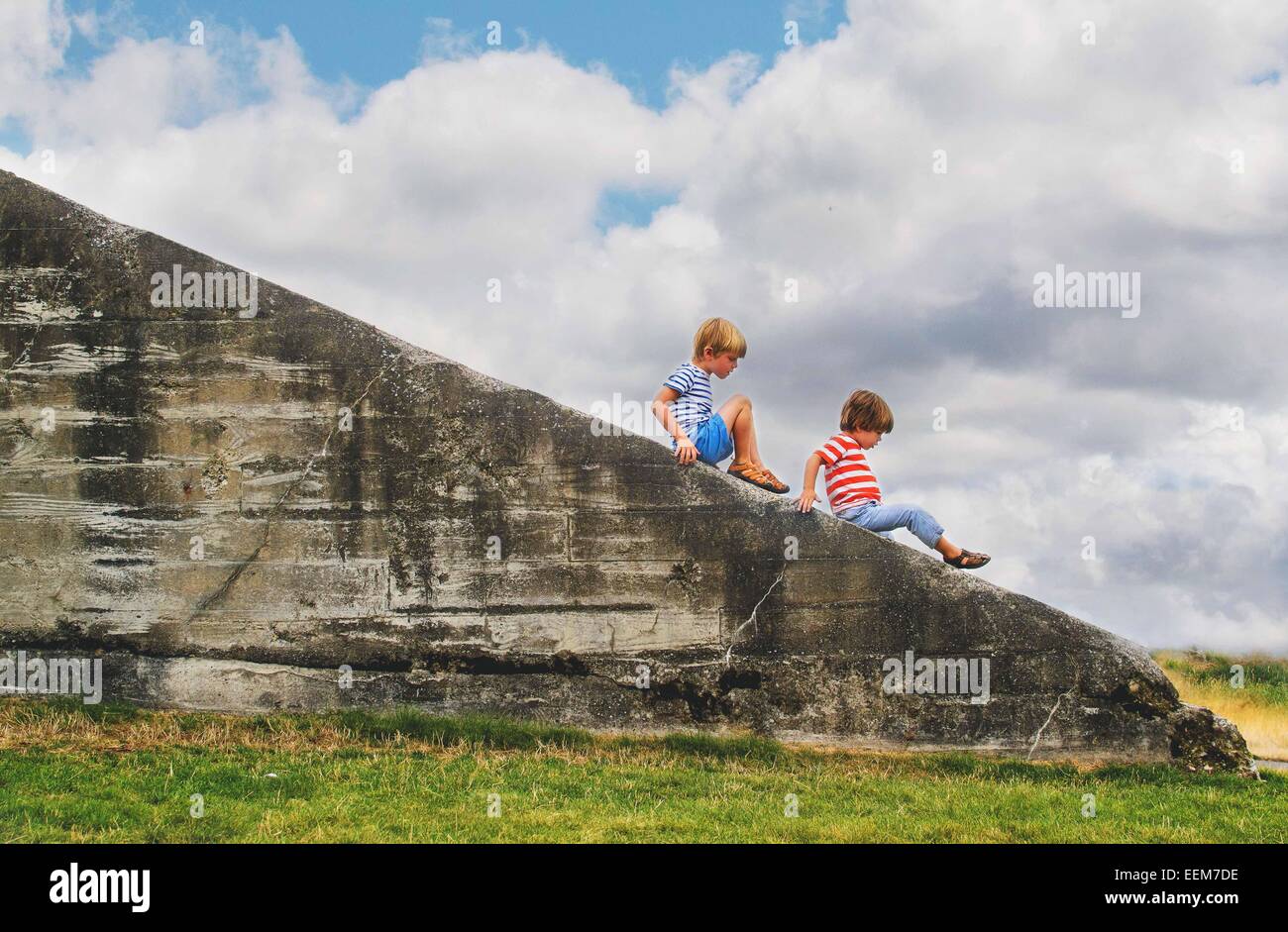 Due ragazzi seduti su un muro Foto Stock