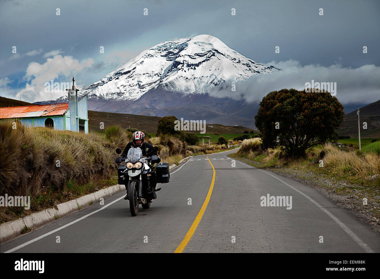 Ecuador, Vista dell uomo in sella moto con il Vulcano Chimborazo in background Foto Stock