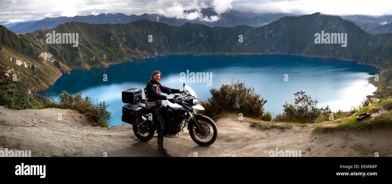Ecuador, uomo sulla moto in posa contro il lago a Laguna Quilotoa Foto Stock