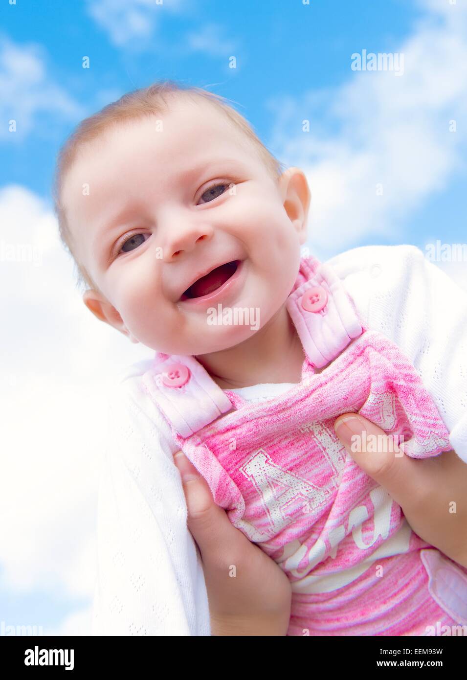 Baby girl (6-11 mesi) raggiungendo per sky Foto Stock