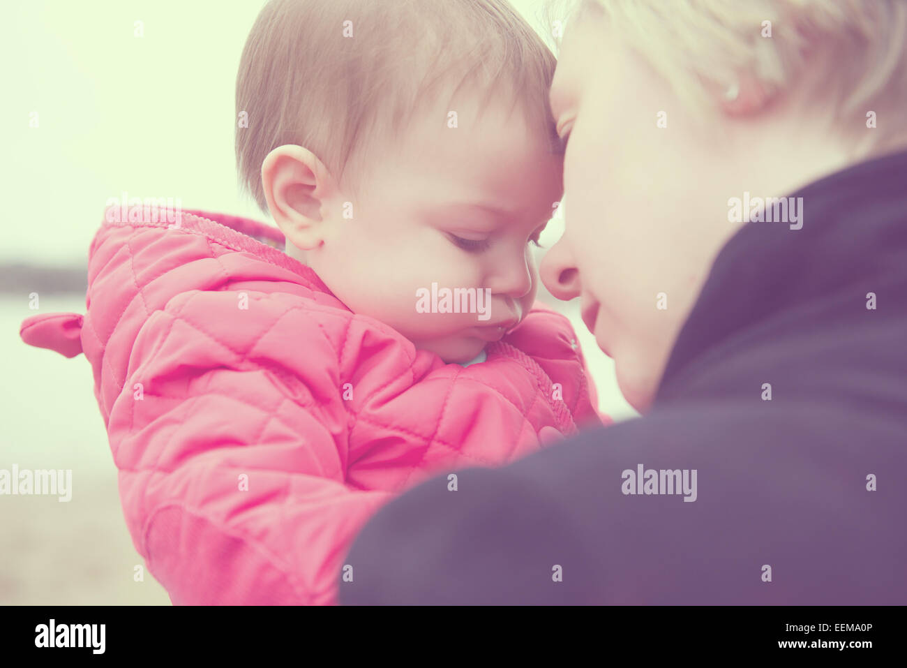 Ritratto di Madre e figlia di bambino (6-11 mesi) toccare fronte Foto Stock