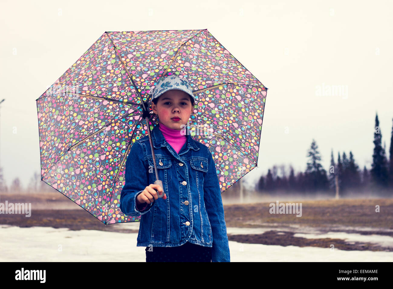 Caucasian ragazza camminare sotto ombrellone in campo nevoso Foto Stock