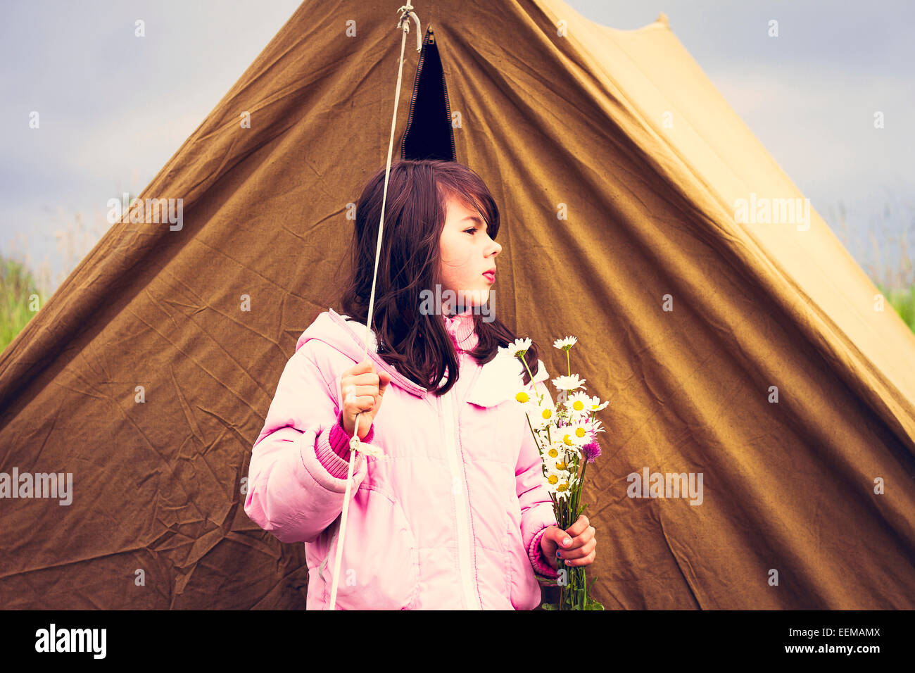 Caucasian ragazza con fiori selvaggi vicino a camp tenda Foto Stock