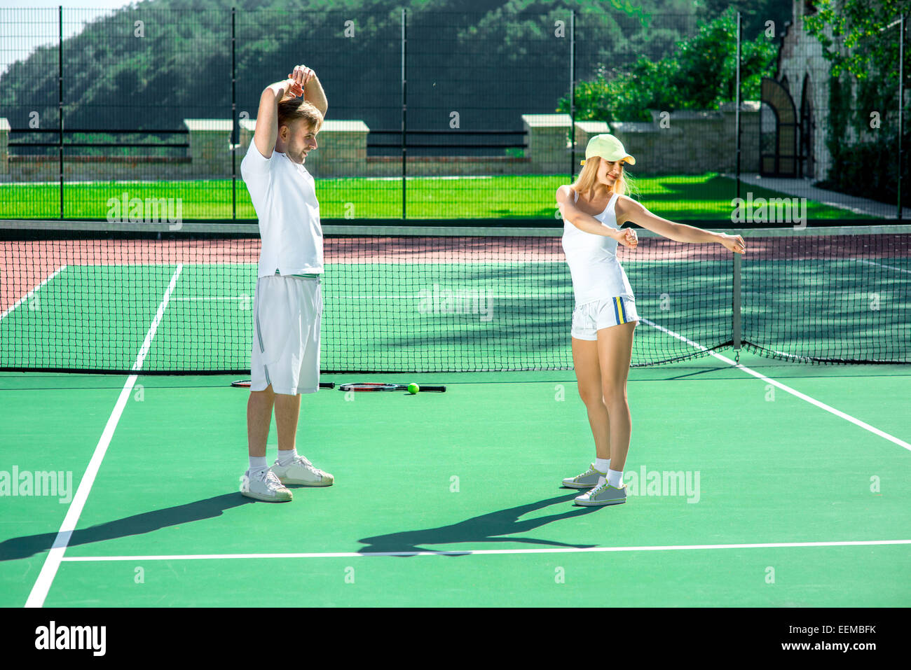 Coppia giovane la formazione sul campo da tennis Foto Stock