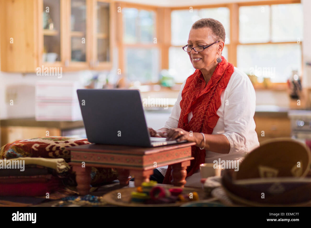 I vecchi razza mista donna utilizzando laptop in home office Foto Stock