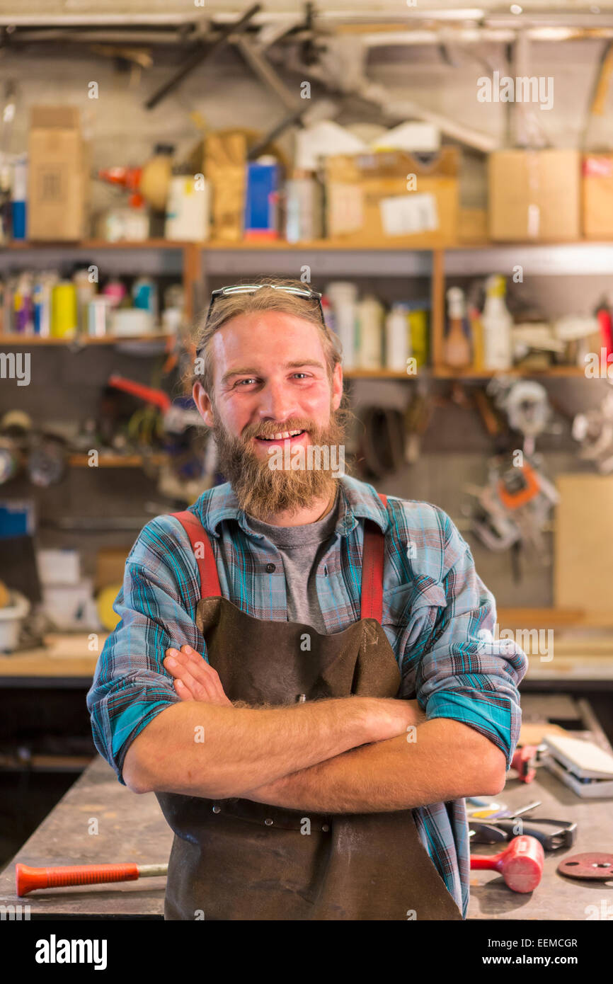 Artigiano caucasica sorridente in officina Foto Stock
